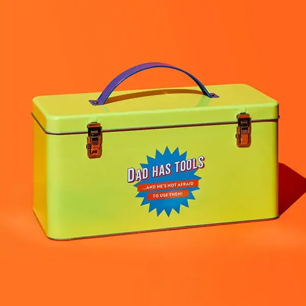 Bright green toolbox gift tin with Dad Has Tools slogan and metal clasps displayed on an orange background